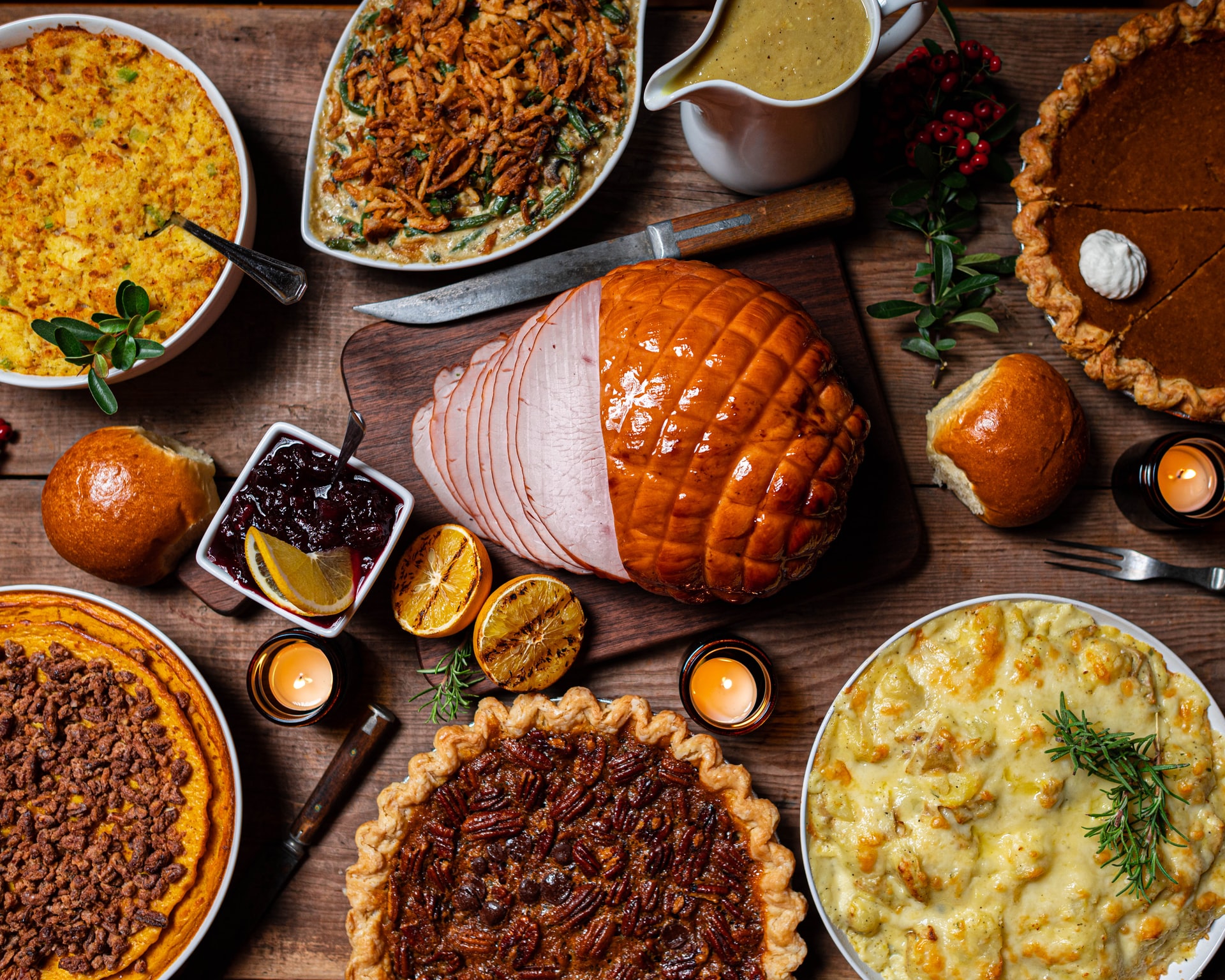 thanksgiving dinner spread consisting of ham, pecan pie, mash potatoes, etc